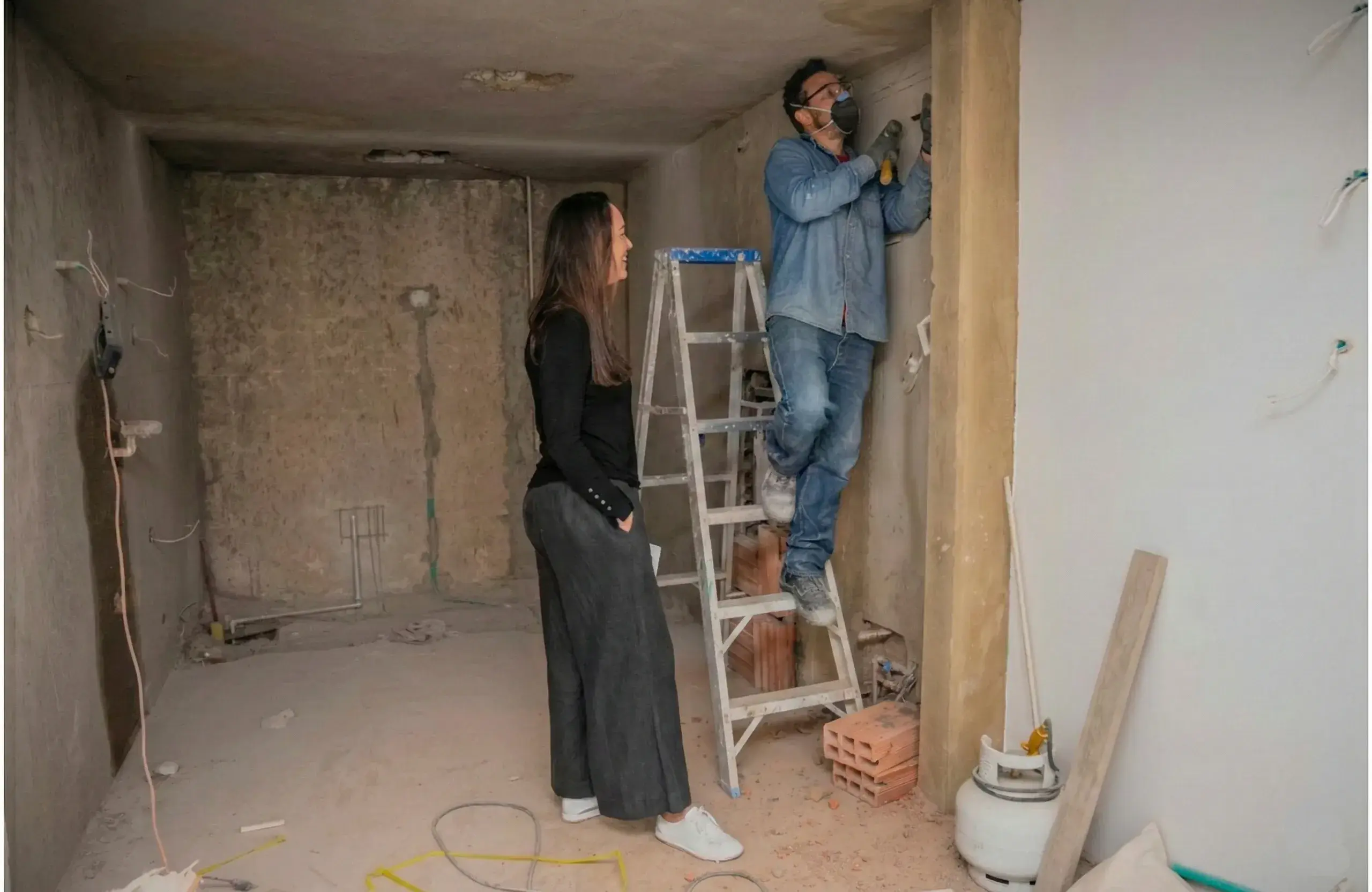 Tecnico edile in cantiere mostra al cliente lo stato avanzamento della ristrutturazione casa